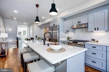 Kitchen with quartz island and stainless appliances